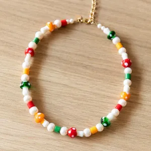 Détail de collier en perles baroques avec perles colorées et breloques champignon