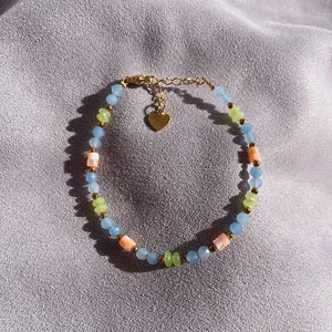 Macro view of colorful faceted natural stone beaded bracelet with heart charm detail