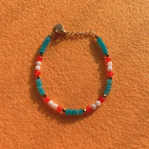 Detail view of colorful faceted natural stone beaded bracelet with golden heart charm