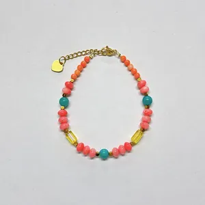 Close-up of colorful candy stone beads and golden heart charm on minimalist bracelet