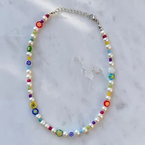 Détail d'un collier avec des perles baroques blanches et perles fleuries colorées