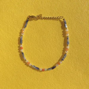 Detail view of a colorful natural stone beaded bracelet with gold accents.
