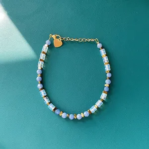 Detailed view of faceted blue natural stone and opalite beaded bracelet on teal leather