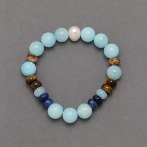 Close-up detail of colorful natural stone beaded bracelet with central white pearl