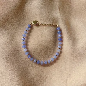 Close-up of faceted purple natural stone beaded bracelet with gold heart clasp