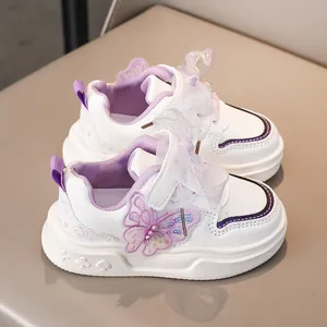 Dettaglio scarpe sportive bianche in pelle per bambina con farfalla e fiocco in pizzo viola