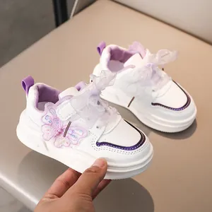 Dettaglio scarpe da ginnastica bianche per bambine con farfalla viola e lacci a rete viola