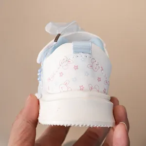 Dettaglio ravvicinato del tallone di una sneaker bianca per bambina con motivo a coniglietto