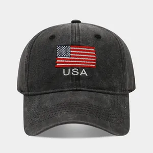 Close-up detail of the embroidered USA flag and text on a washed black cotton baseball cap