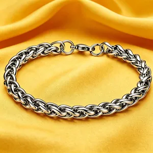 Primo piano di un bracciale a catena in acciaio inossidabile argento su tessuto giallo