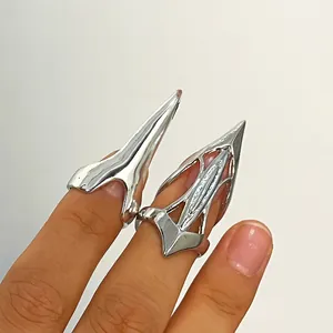 Detail shot of silver pointed nail rings in cyberpunk gothic style worn on fingers.