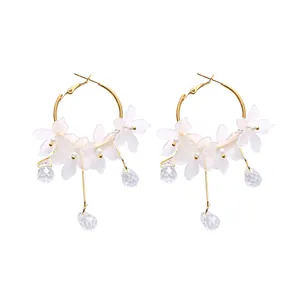 Elegant hoop earrings featuring frosted white flower petals and faceted crystal drops.