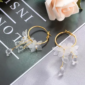 Detailed view of elegant gold hoop earrings with frosted flower petals and crystal drops