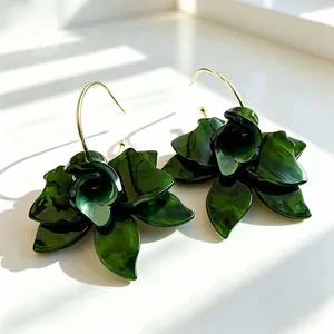 Elegant dark green acetate flower drop earrings with gold-toned hooks in sunlight.