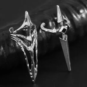 Detailed macro view of two silver-toned punk style pointed nail rings with gothic designs.