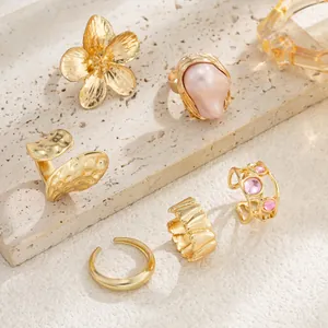 Detailed view of gold lava flower rings with baroque faux pearls and pink gems.