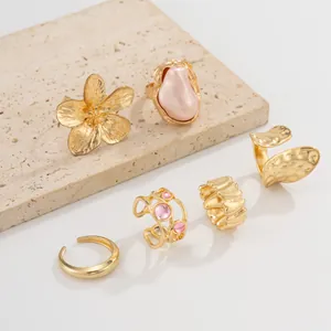 Set of gold baroque rings featuring imitation pearl and liquid lava flower designs