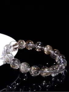 Macro view of a natural silver rutilated quartz bracelet with clear needle-like inclusions
