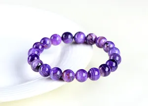 Vue macro de perles de charoïte violette naturelle aux motifs tourbillonnants uniques
