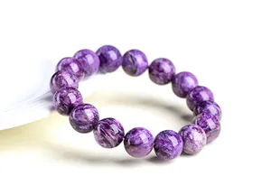 Gros plan d'un bracelet en perles de Charoite naturelle aux motifs violets