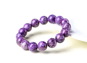 Vue rapprochée de perles de charoite violette naturelle avec des motifs uniques