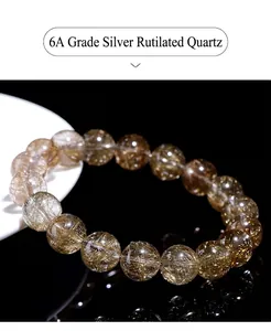 Macro detail of natural silver rutilated quartz beads with dense needle inclusions.
