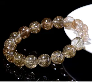 Macro detail of natural silver rutilated quartz bracelet showing golden needle inclusions