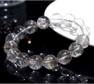 Close-up detail of natural silver rutilated quartz beads showing internal hair texture.