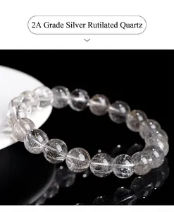 Macro view of natural silver rutilated quartz beads bracelet with silver needle-like inclusions