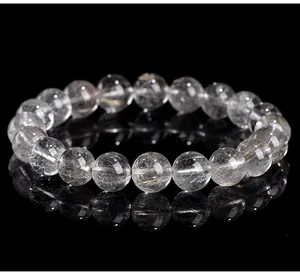 Macro view of natural silver rutilated quartz beads showing intricate internal rutiles.