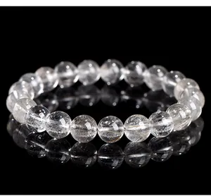 Macro view of natural 7A silver rutilated quartz round beads bracelet on black background