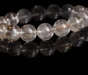 Macro detail of natural silver rutilated quartz beads showing internal silver hair-like rutiles