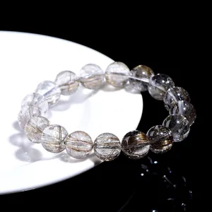 Natural 7A grade silver rutilated quartz bead bracelet on a white plate.