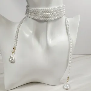 Detalle de gargantilla de perlas multicapa con colgantes barrocos en un busto de maniquí