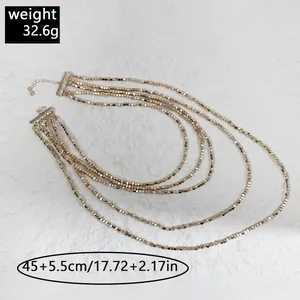 Vista detallada de un collar multicapa de cuentas doradas con acentos de diamantes