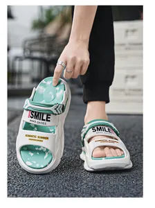 Nahaufnahme trendiger weißer EVA-Plateau-Sandalen mit grünem Inlay in Marmor-Optik.
