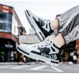 Detailed side view of stylish black and white mid-top sneakers in an urban street setting
