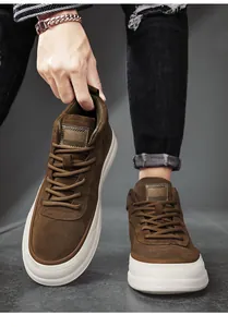 Detail view of brown suede mid-top shoes with thick white soles and matching laces.