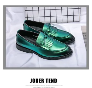 Mocasines de hombre en verde metálico con borlas decorativas y detalle de lazo en primer plano