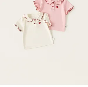 Close-up view of sweet girl's t-shirts featuring ruffle collars and strawberry embroidery