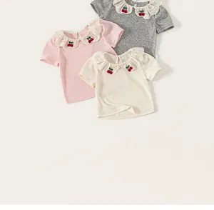 Detail view of girls' short-sleeve T-shirts with ruffled collars and cherry embroidery