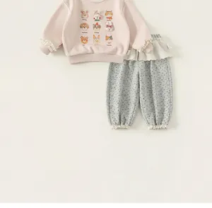 Dettaglio felpa rosa da bambina con stampe di animali carini e pantaloni a pois grigi