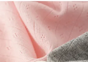 Close-up of soft breathable cotton fabric with pointelle pattern for baby girls