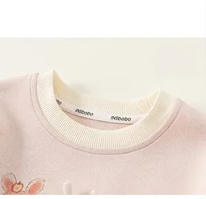 Dettaglio felpa rosa da bambina con girocollo bianco a contrasto e stampa cartoon