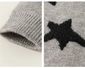 Detail van grijze kindertrui met geribbelde manchet en zwart sterrenpatroon