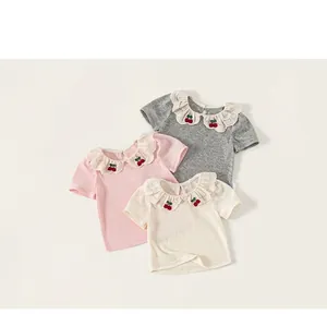 Detail shot of girls' cotton T-shirts with ruffled collars and cherry embroidery