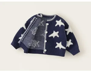 Detailweergave van donkerblauw gebreid vest met opvallende witte sterpatronen voor meisjes.