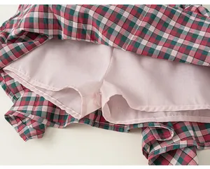 Dettaglio ravvicinato di una gonna scozzese da bambina con fodera interna rosa anti-riflesso.