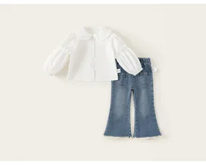 Stylish girls spring clothing set with white ruffled shirt and denim flare pants detail
