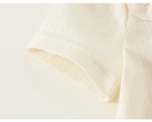 Detail of cream pointelle knit fabric and scalloped lace collar on girl's T-shirt